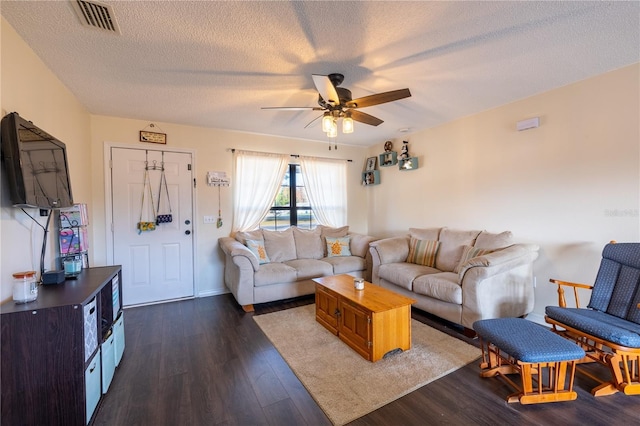 living room featuring a textured ceiling, dark hardwood / wood-style floors, and ceiling fan