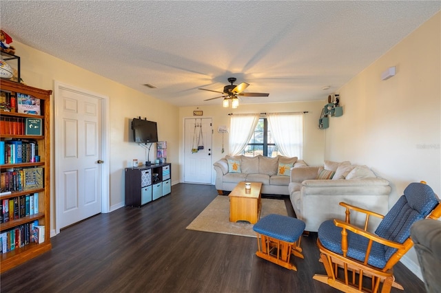 living room with ceiling fan, dark hardwood / wood-style flooring, and a textured ceiling