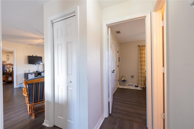 hallway featuring dark hardwood / wood-style flooring and a textured ceiling