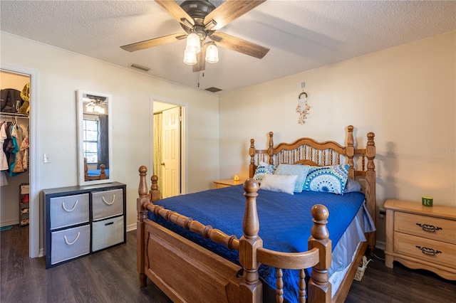 bedroom with dark hardwood / wood-style floors, ceiling fan, a textured ceiling, and a closet