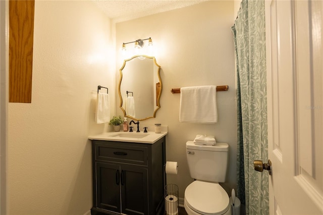 bathroom with vanity, a textured ceiling, and toilet