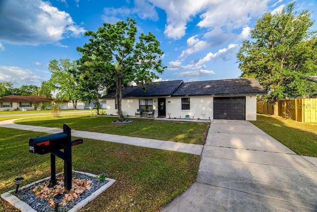 single story home featuring concrete driveway, stucco siding, an attached garage, a front yard, and fence
