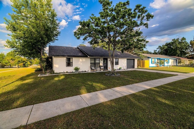 single story home featuring a front yard, stucco siding, a garage, and concrete driveway