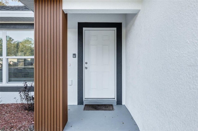 property entrance with stucco siding