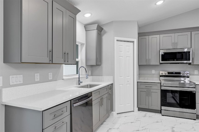 kitchen featuring gray cabinets, sink, stainless steel appliances, and lofted ceiling