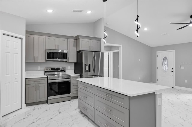 kitchen with pendant lighting, gray cabinetry, a center island, vaulted ceiling, and stainless steel appliances