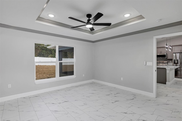 empty room with ceiling fan, ornamental molding, and a tray ceiling