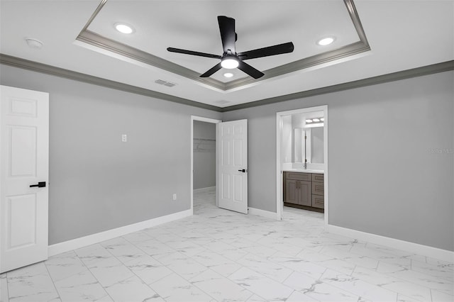 unfurnished bedroom with a tray ceiling, ceiling fan, and ornamental molding