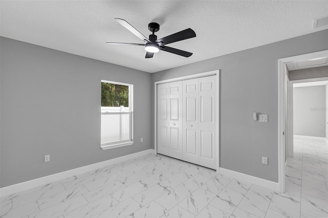 unfurnished bedroom featuring ceiling fan, a textured ceiling, and a closet