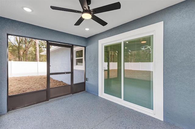 unfurnished sunroom featuring ceiling fan