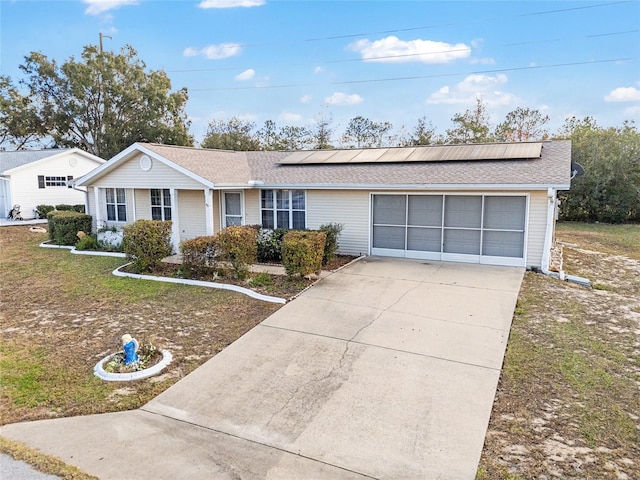 single story home featuring a front lawn, solar panels, and a garage