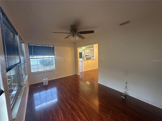 empty room with ceiling fan and dark hardwood / wood-style floors