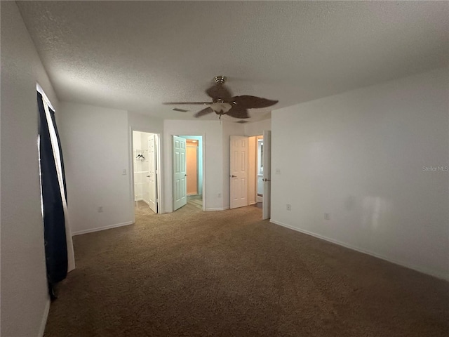 unfurnished bedroom featuring light carpet, ensuite bath, baseboards, and a textured ceiling