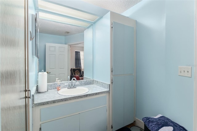 bathroom with vanity and a textured ceiling