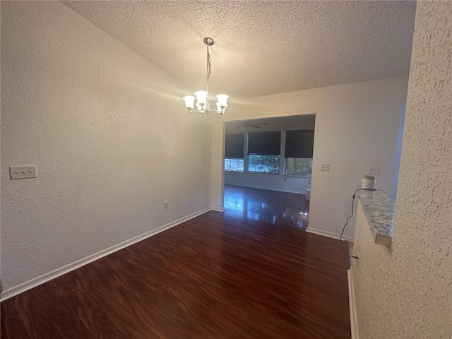 unfurnished dining area featuring a textured ceiling, dark hardwood / wood-style floors, and a notable chandelier