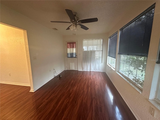 spare room with ceiling fan, dark hardwood / wood-style floors, and a textured ceiling