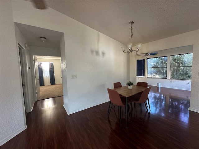 dining area featuring a chandelier, a textured ceiling, baseboards, and wood finished floors