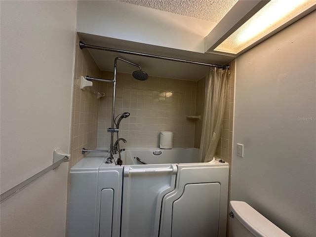 full bathroom with toilet, washer / dryer, and shower / bath combo