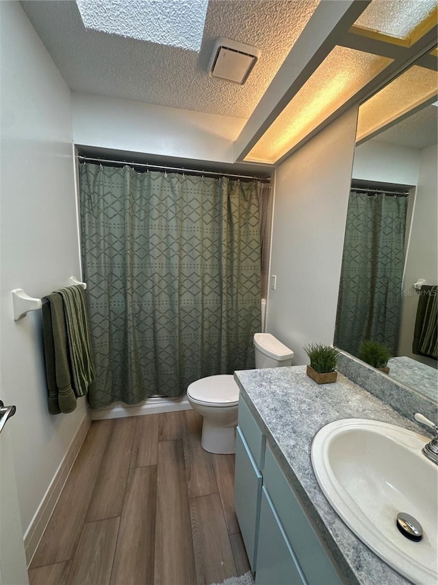 8968 SW 116th Place Rd, Ocala, FL 34481 - full bath featuring vanity, toilet, wood finished floors, curtained shower, and a textured ceiling
