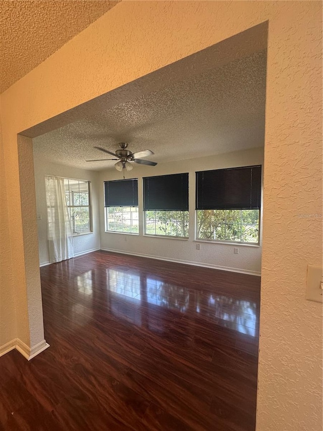 8968 SW 116th Place Rd, Ocala, FL 34481 - empty room featuring a textured wall, a textured ceiling, healthy amount of natural light, wood finished floors, and baseboards