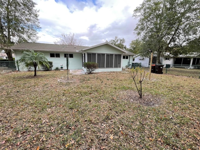 back of property featuring a sunroom and a yard