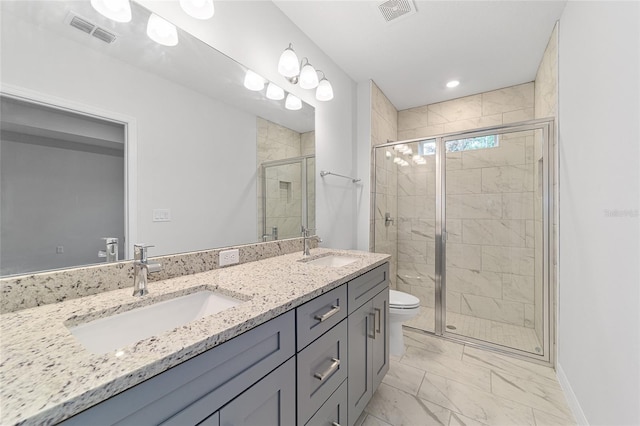 bathroom featuring vanity, a shower with shower door, and toilet