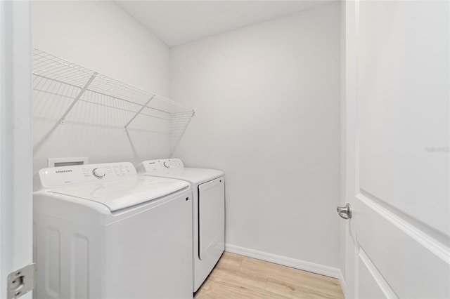 laundry room featuring light wood-type flooring and washing machine and clothes dryer