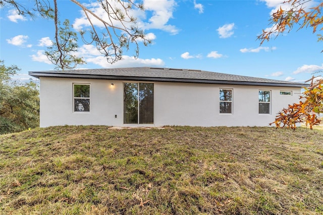 rear view of property with a lawn