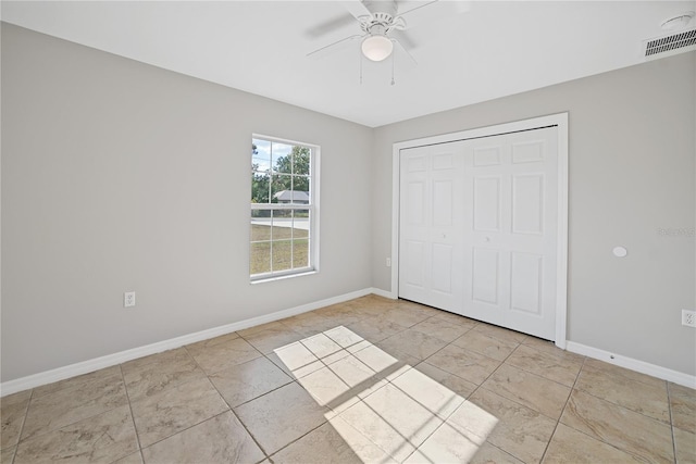 unfurnished bedroom featuring ceiling fan and a closet