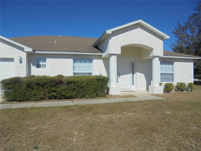 ranch-style house featuring a garage and a front lawn