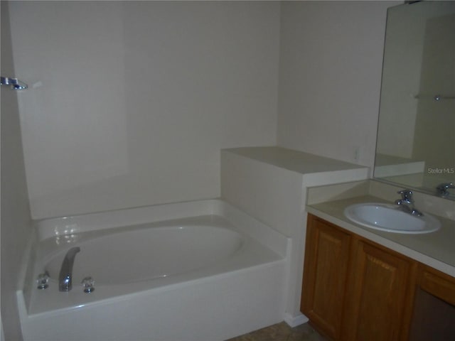 bathroom featuring a washtub and vanity