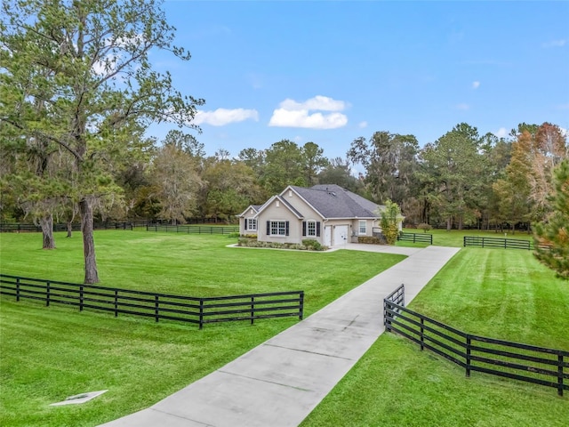 view of front facade featuring a garage, a rural view, and a front yard