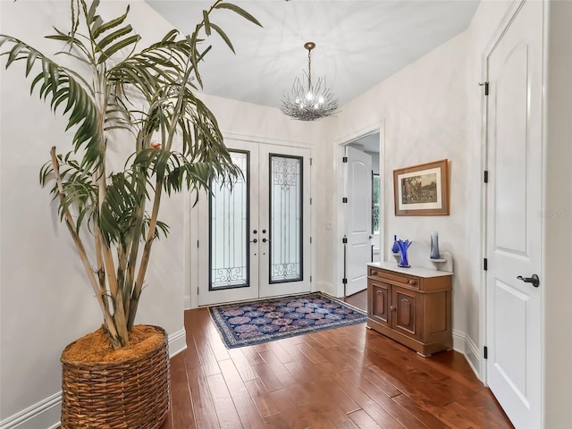 entrance foyer featuring french doors, dark hardwood / wood-style flooring, and a notable chandelier