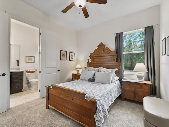 carpeted bedroom featuring ensuite bathroom and ceiling fan