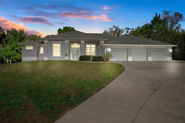 view of front facade with a garage and a lawn