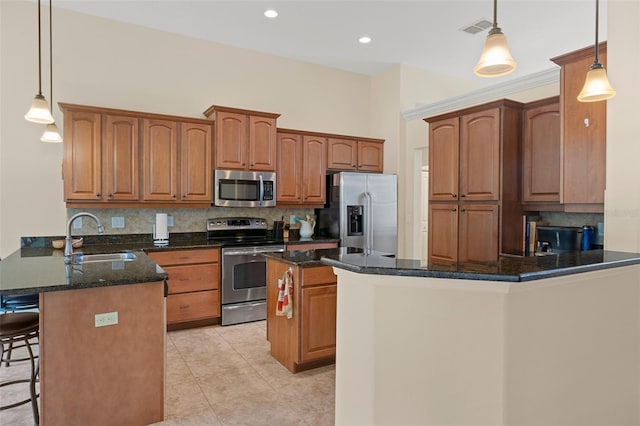 kitchen featuring kitchen peninsula, hanging light fixtures, appliances with stainless steel finishes, and tasteful backsplash