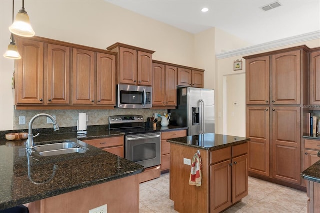 kitchen with pendant lighting, stainless steel appliances, dark stone counters, and sink