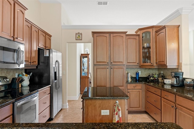 kitchen with backsplash, dark stone countertops, and stainless steel appliances