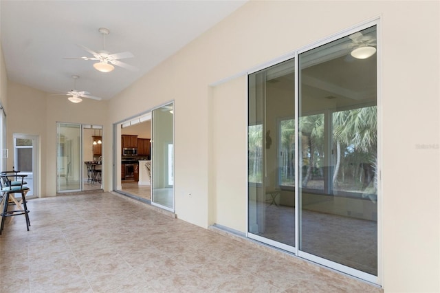 unfurnished sunroom with ceiling fan