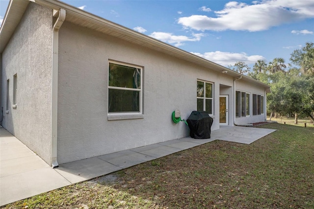 rear view of property featuring a lawn and a patio