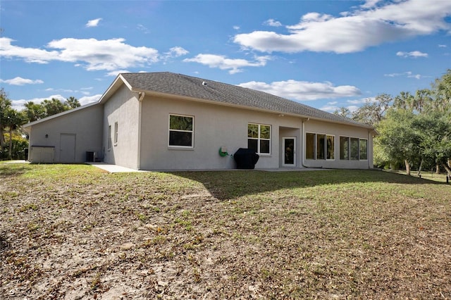 rear view of property featuring central AC and a lawn