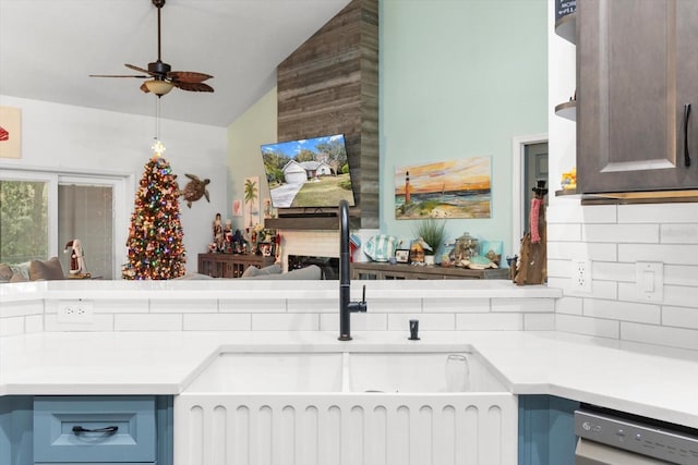 kitchen with ceiling fan, dishwasher, sink, tasteful backsplash, and vaulted ceiling