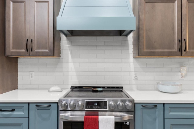 kitchen with tasteful backsplash, stainless steel range, and ventilation hood