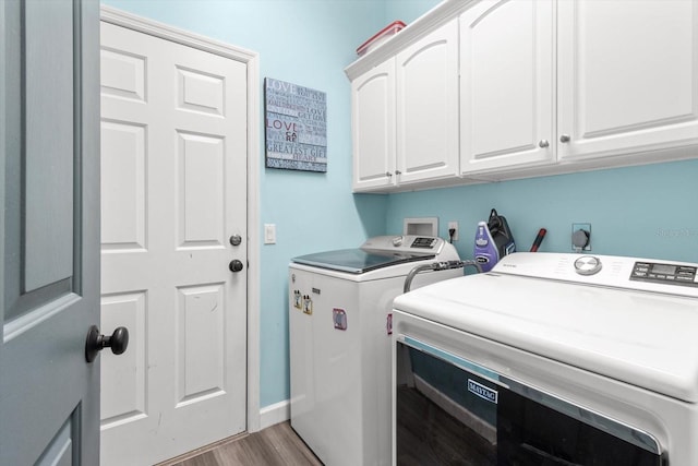 laundry area featuring separate washer and dryer, cabinets, and light wood-type flooring