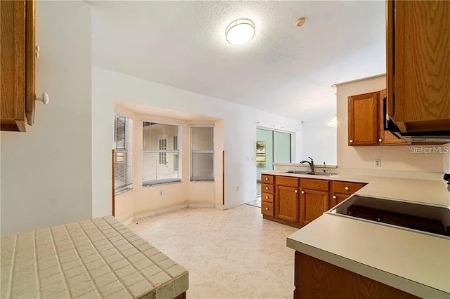 kitchen with kitchen peninsula, sink, and a textured ceiling