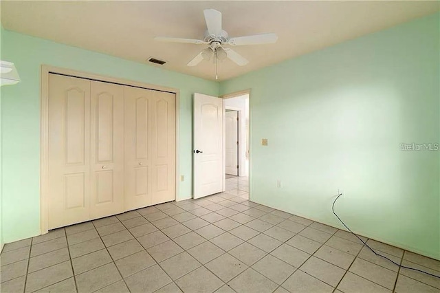 unfurnished bedroom with ceiling fan, light tile patterned floors, and a closet