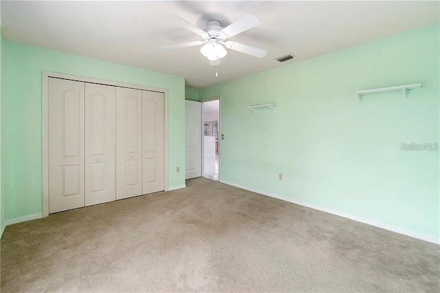 unfurnished bedroom featuring carpet, a closet, and ceiling fan