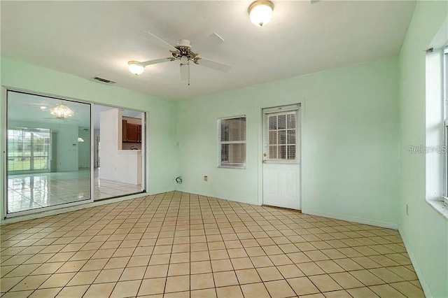 unfurnished room with ceiling fan, a healthy amount of sunlight, and light tile patterned floors