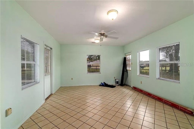 tiled spare room featuring ceiling fan