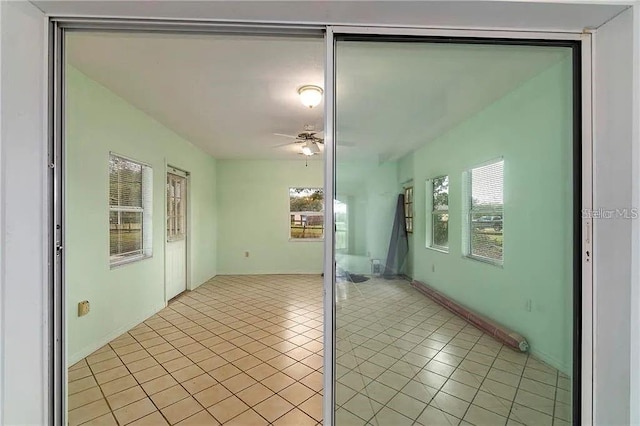 unfurnished room with ceiling fan and light tile patterned floors